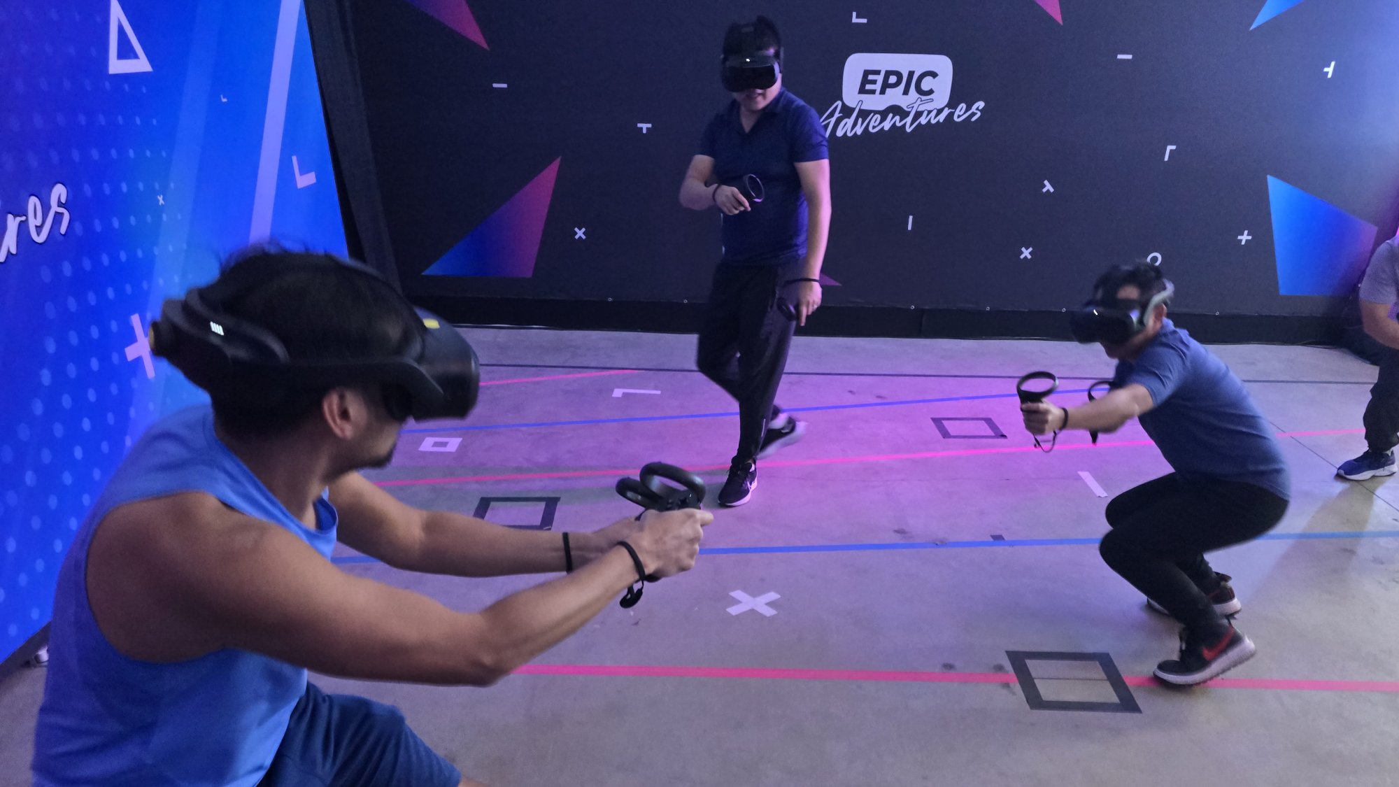 Three players crouching and aiming in an intense free-roam VR game at Epic Adventures in Vancouver WA