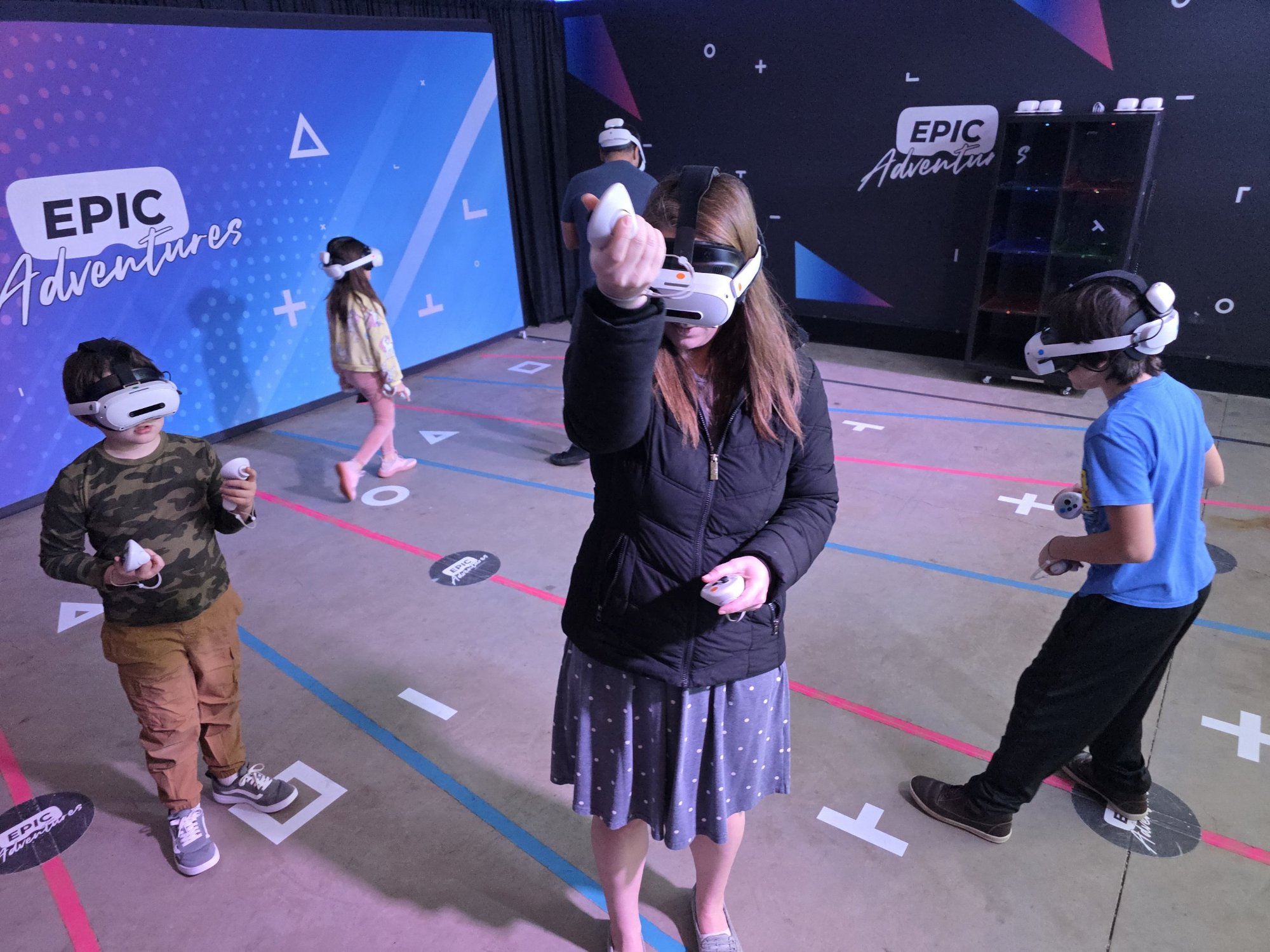 Family playing VR escape adventure together with mom and kids in headsets at Epic Adventures