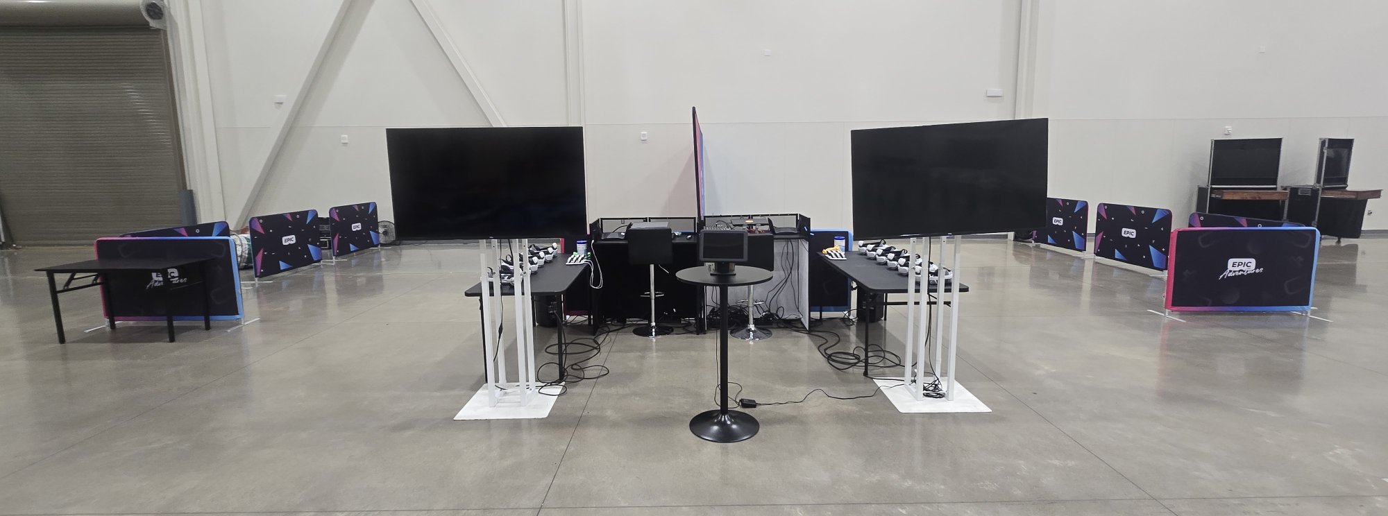 Epic Adventures dual mobile VR arena setup with two side-by-side arenas, branded barriers, spectator screens, and 12 headsets ready for a large corporate event